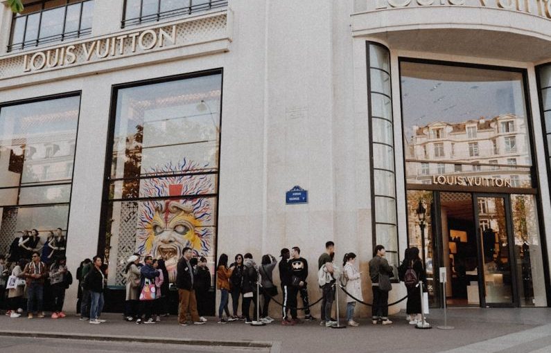 Luxury Shopping - people queuing beside Louis Vuitton store