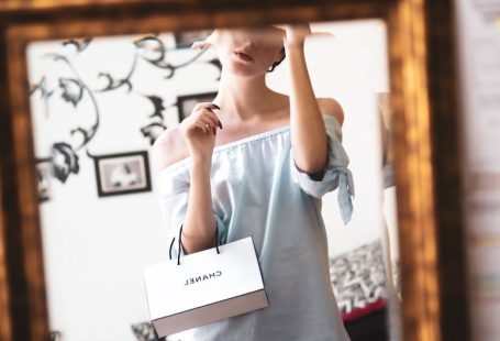 Luxury Shopping - woman in white long sleeve shirt holding white printer paper