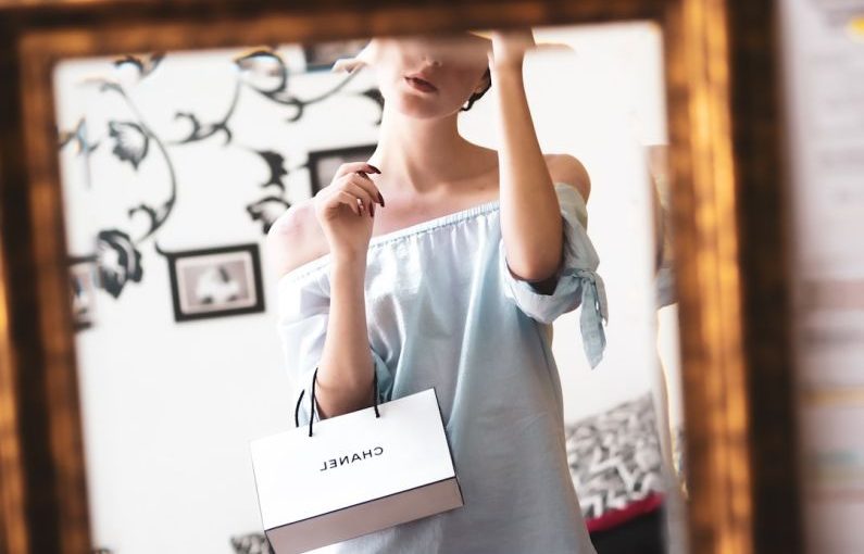 Luxury Shopping - woman in white long sleeve shirt holding white printer paper
