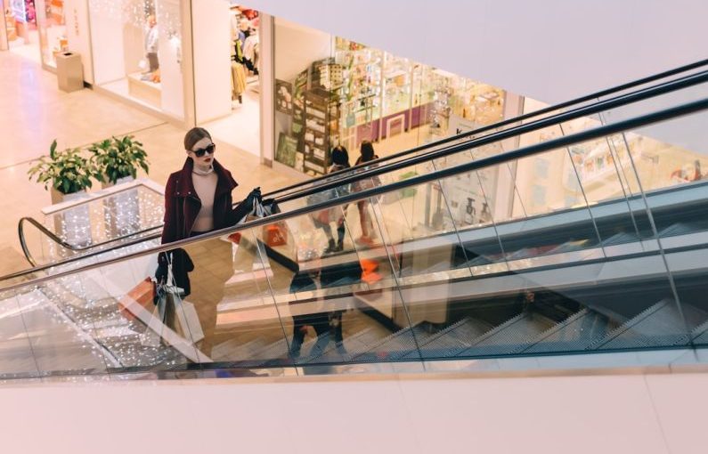 Luxury Shopping - woman riding escalator