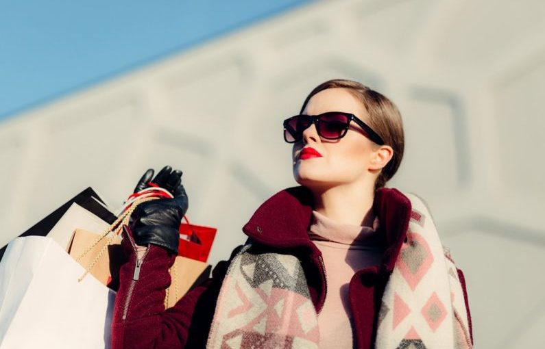 Luxury Shopping - shallow focus photography of woman holding shopping bags during day