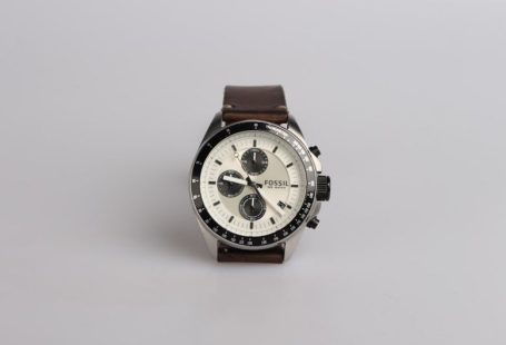 Watch - round silver-colored Fossil chronograph watch at 9:22 with brown leather band