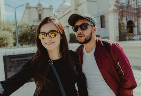 Glasess - man in black crew neck shirt beside woman in red cardigan