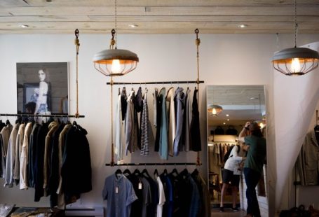 Luxury Shopping - person leaning on wall while holding gray hat