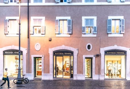 Luxury Shopping - person walking on the sidewalk beside the building