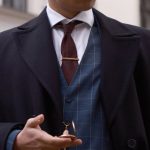 Tie Clip - A man in a suit and tie is standing on a street
